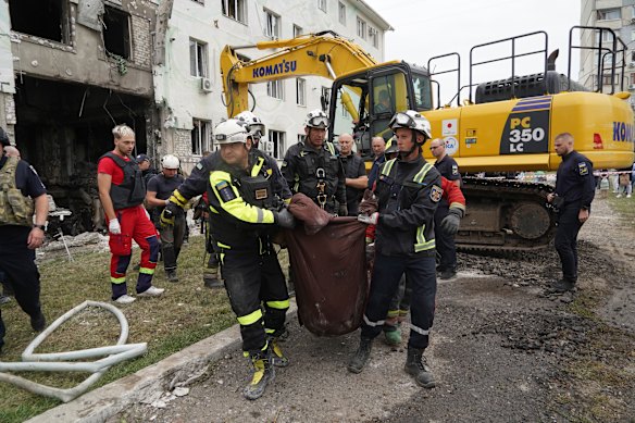 Rescuers carry a body from a residential building damaged by a Russian attack on Kharkiv, Ukraine, on Monday.