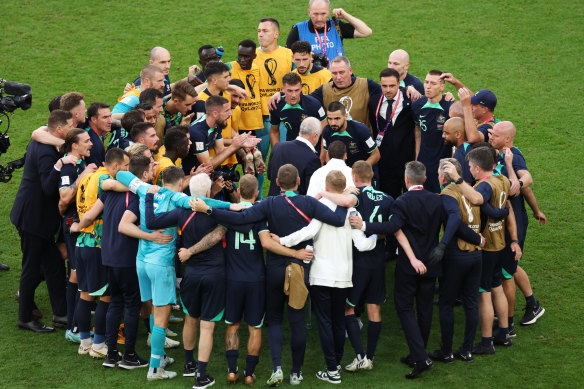 Australian players and staff huddle after their 1-0 victory.