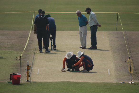 Pakistani players inspect the pitch at Lahore on Sunday.