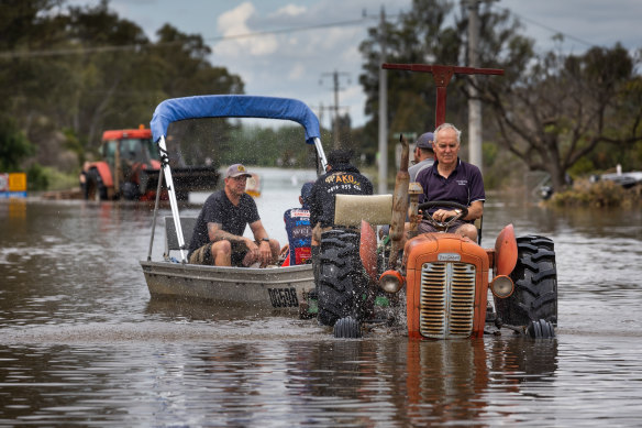 Ray Cross transports sandbags and people down Goulburn Road as part of efforts to stop floodwaters in Echuca East.