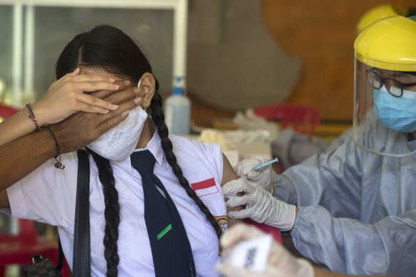 A teenager receives vaccine at a school in Bali, Indonesia.