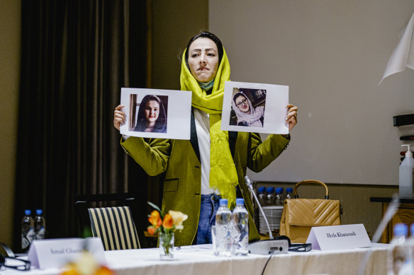 Delegate from the Afghan civil society Heda Khamoush holds up photos of two women who have vanished, ahead of a meeting, in Oslo, Norway, on January 24.