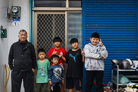 Lee Jin-He and his grandchildren outside his house that sits behind the air base in Hualien, Taiwan.