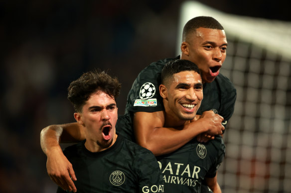 Achraf Hakimi (centre) celebrates with PSG’s other goalscorer, Kylian Mbappe (right) and Vitinha.