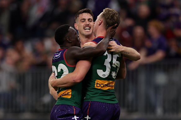 Josh Treacy celebrates a goal with Michael Frederick and Patrick Voss.