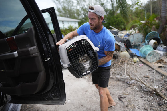 A friend packs Evan Purcell’s cat as they evacuate Anna Maria Island in Florida.