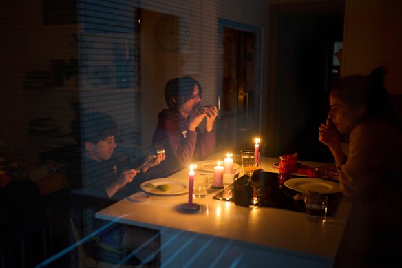 A family eats a snack by candlelight during a blackout in Barcelona, Spain.