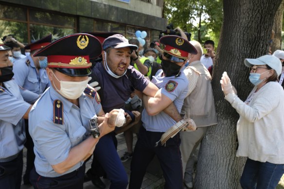 Police wearing a face masks to protect against coronavirus, detain a protester during a protest in Almaty, Kazakhstan last month.