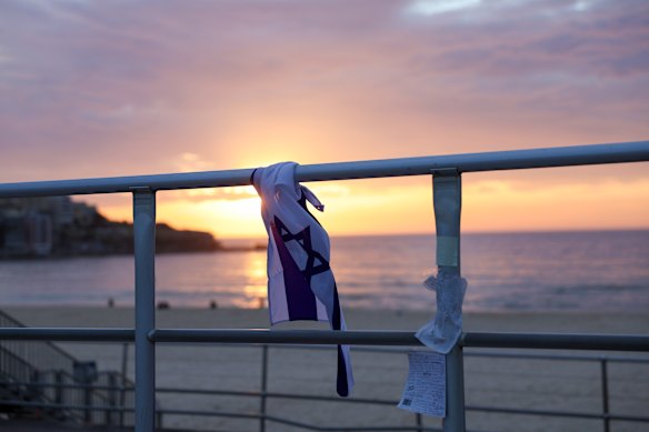 An Israeli flag furled on the boardwalk railing at Bondi Beach.