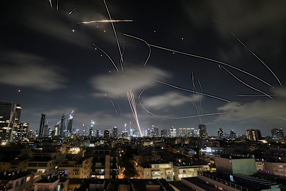 Missiles and interceptor rockets streak across the skies of Tel Aviv.