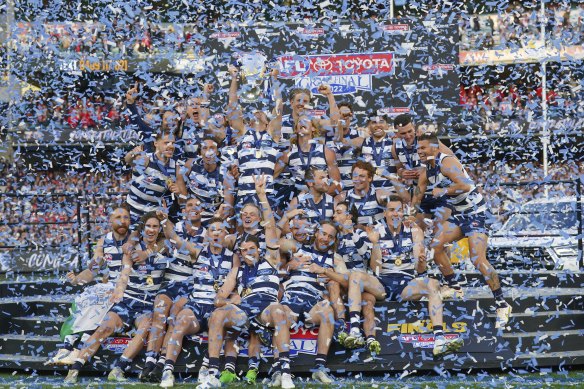 The victorious Cats lift the premiership cup.