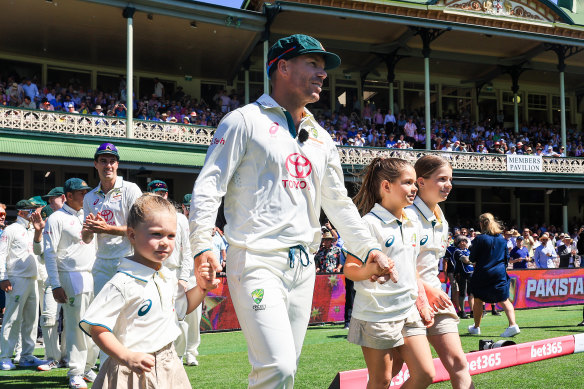 David Warner makes his way onto the pitch for his 112th and final Test, with daughters Isla, Indy and Ivy.