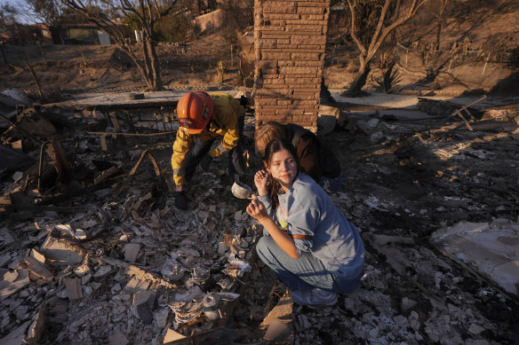 Ella Venne holds a cup she found in the remains of her family’s home destroyed by the Eaton Fire.