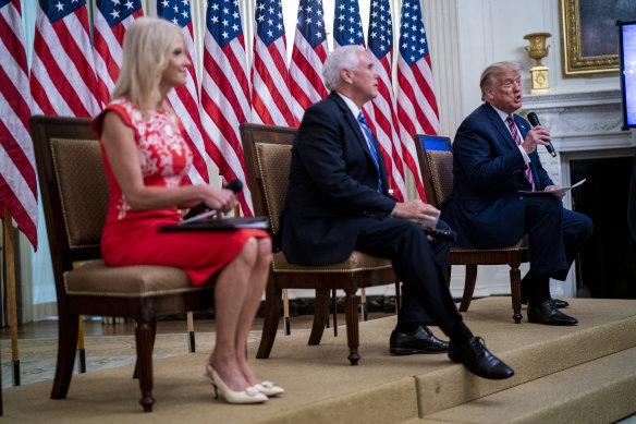 President Donald Trump, right, speaks while Kellyanne Conway, left, and Vice-President Mike Pence listen during an event on reopening schools earlier this month.