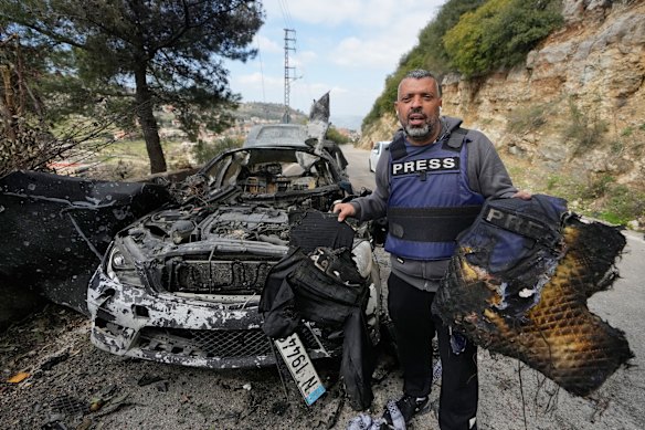 A journalist carrying burnt safety equipment, following an Israeli airstrike on a car that killed Hezbollah al-Manar reporter Ali Shoeib, Beirut Al-Mayadeen TV channel reporter Fatima Ftouni and her brother, video journalist Mohammed Ftouni, in Jezzine, southern Lebanon.