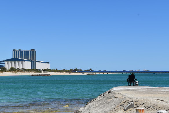 A fisher contemplates the water – or perhaps the CBH grain terminal and jetty.