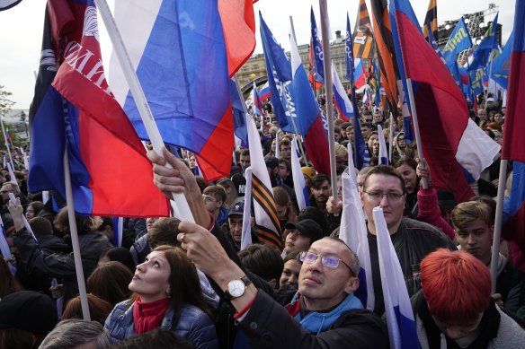 Demonstrators hold Russian state flags, flags with the letter Z, which has become a symbol of the Russian military, and a hashtag reading “We don’t abandon our own” during the action.