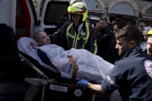 An injured man is loaded into an ambulance after an attempted stabbing in the Mahane Yehuda market in Jerusalem on Wednesday.