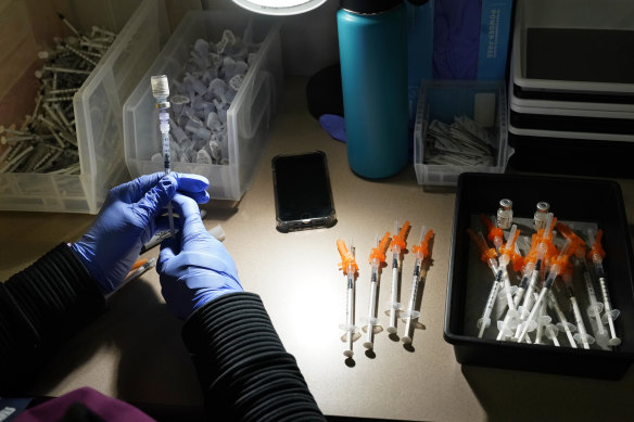 A nurse fills syringes with Pfizer vaccines at a COVID-19 vaccination clinic. 