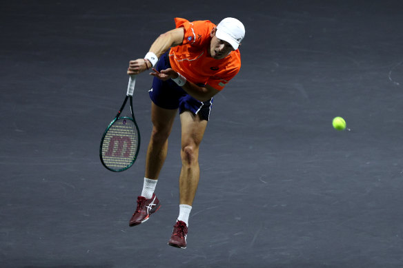 De Minaur serves against Grigor Dimitrov.