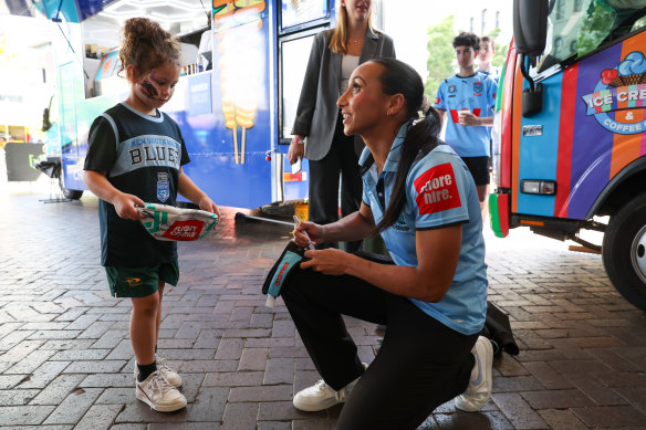 Cronulla winger Cassie Staples talks with a young fun at the NRL fan festival.