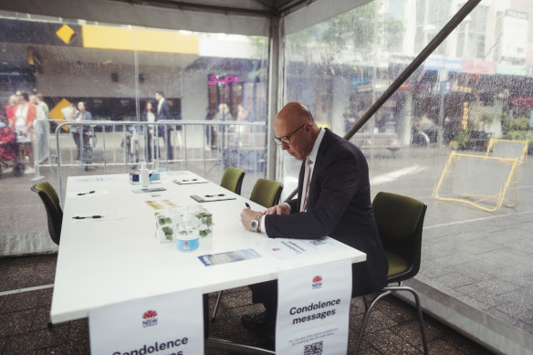 Peter Dutton writes a condolence note at the Bondi Junction memorial.