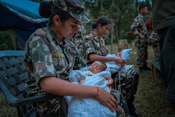 Soldiers carry babies rescued from isolated towns and airlifted to a military camp in Trishuli, Nepal. 