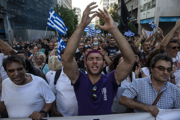 Anti-vaccine protesters shout slogans as they march to the parliament, in Athens, on Saturday.