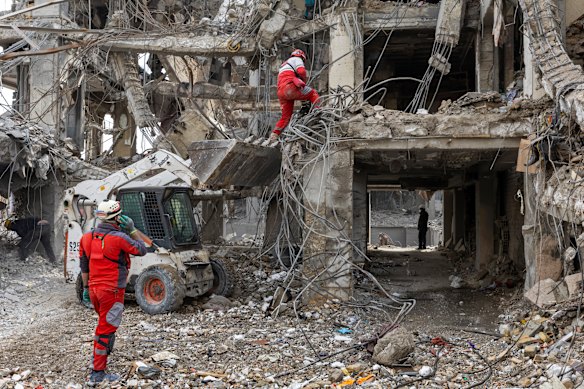 Operai e civili cercano tra le macerie degli edifici residenziali distrutti dagli attacchi statunitensi e israeliani a Teheran.