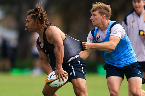 Issak Fines-Leleiwasa passes under pressure from Tate McDermott at training.