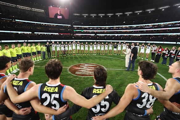 St Kilda, Carlton and the umpires link arms before Spud’s Game earlier this season.