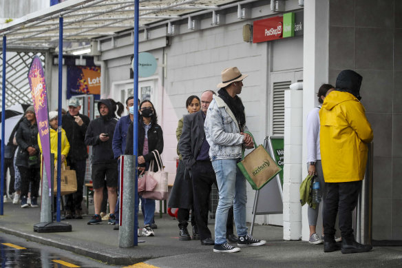 Shoppers line up to enter a supermarket in Auckland on Tuesday. The city is going into a snap seven-day lockdown.