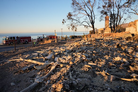 A Travis County, Texas Fire Engine 102, left, is statio<em></em>ned at the Asiliomar Bluffs as the sun rises over homes destroyed by the Palisades Fire in the Pacific Palisades neighborhood of Los Angeles.