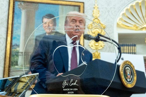 Donald Trump dengan hadiah dari kepala Apple, Tim Cook.