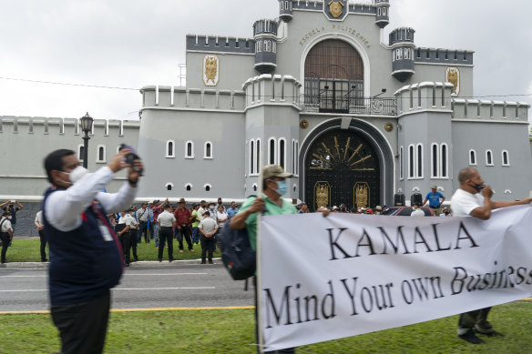 rotesters hold a sign saying “Kamala Mind Your Own Business” as the motorcade of Vice-President Kamala Harris travels to the National Palace, Monday, June 7, 2021, in Guatemala City. 