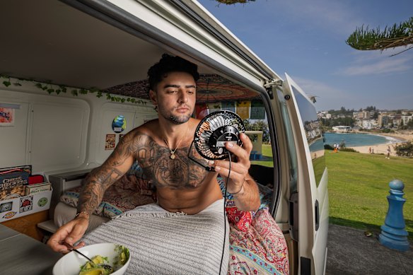 Patrick Mahony cools off in his van with a portable fan at Coogee.