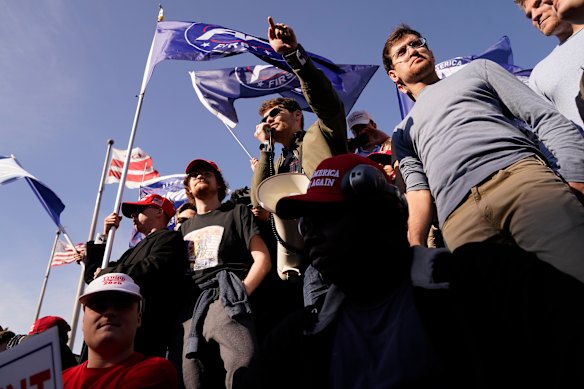 Right-wing podcaster Nick Fuentes (centre) speaks to Trump supporters at a rally in November 2020.