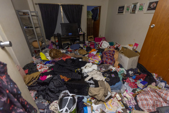 Piles of personal belongings, rotten food and discarded items litter the floor of a vacated apartment.