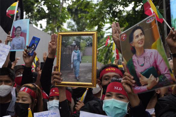 Myanmar nationals living in Thailand hold the pictures of deposed Myanmar leader Aung San Suu Kyi as they protest outside Myanmar’s embassy in Bangkok.