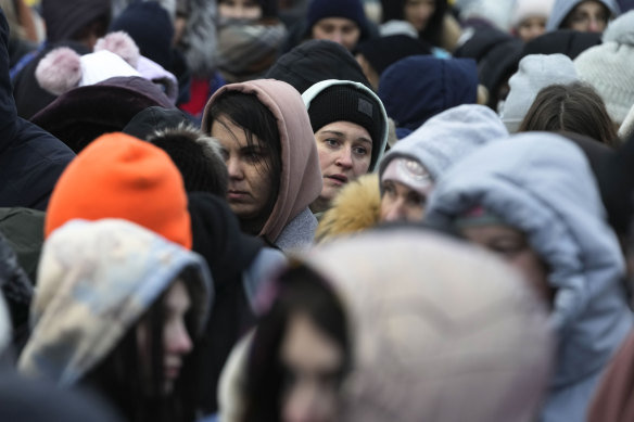 Refugees, mostly women and children, wait in a crowd for transportation after fleeing from the Ukraine and arriving at the border crossing in Medyka, Poland, on Monday, March 7.