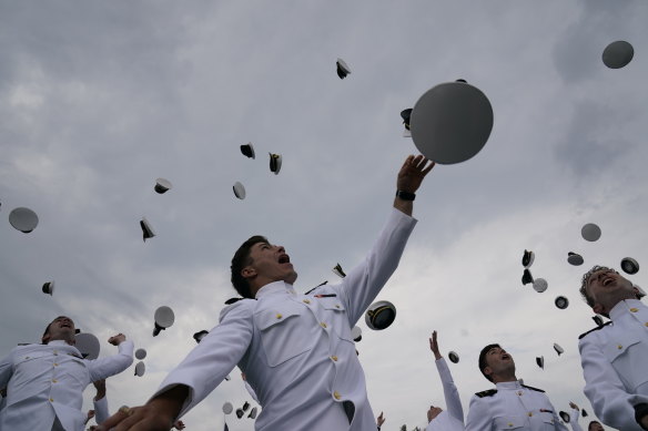 Graduates of the US Naval Academy class of 2021 throw their hats after Vice-President Kamala Harris delivered their commencement speech on the day the White House delivered the 2022 fiscal budget.