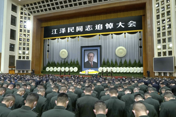 Attendees bow during a formal memorial for the late former Chinese president Jiang Zemin held in Beijing. 