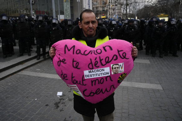 A demonstrator holds a heart reading “Macron I hate you from all my heart” during a demonstration in Paris.