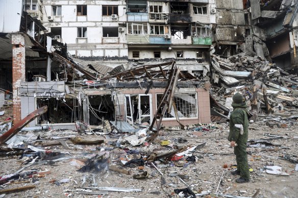 A serviceman stands at a building damaged during fighting in Mariupol, on the territory which is now under the control of the self-determined Donetsk People’s Republic.