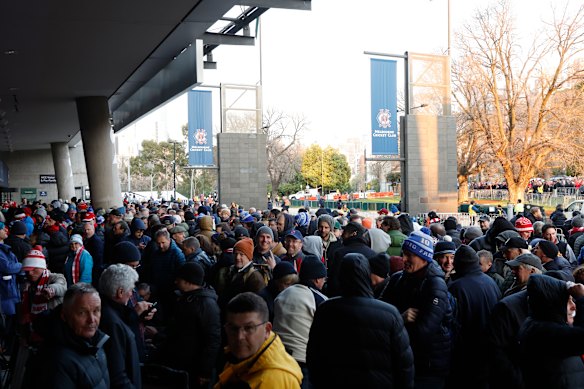 Football fans line up outside the members gates before the AFL Grand Final match between Sydney Swans and Brisbane Lions.