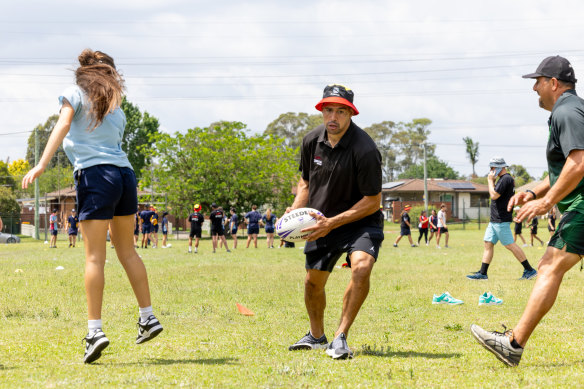Cody Walker throws the football around with kids during a Goanna Academy day in Sydney’s west.