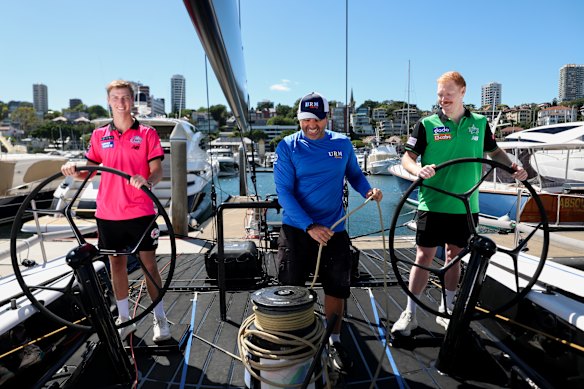 Sydney Sixers Lachie Shaw, left, and Melbourne Stars Liam Hatcher, right, with boat captain of URM Group.