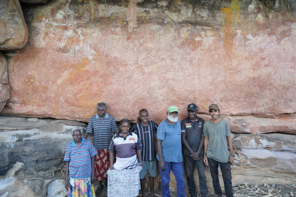 Gunbalanya community members below Majumbu’s rock painting of a crocodile in September 2022 (L-R Priscilla Bardi, Merrill Namundja, Katie Nayingul, Lorraine Namarnyilk, Kenneth Mangiru, Ezaiah Kelly and Jarrod Nabulwad).