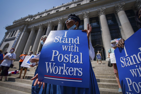 Retired postal worker Glenda Morris protests in New York. Cost-cutting measures at the US Postal Service have now been postponed until after the November election.