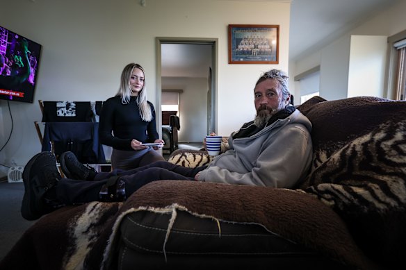 NDIS client Peter Barry at home with support worker Ella Williams. Peter will lose support hours due to funding cuts.